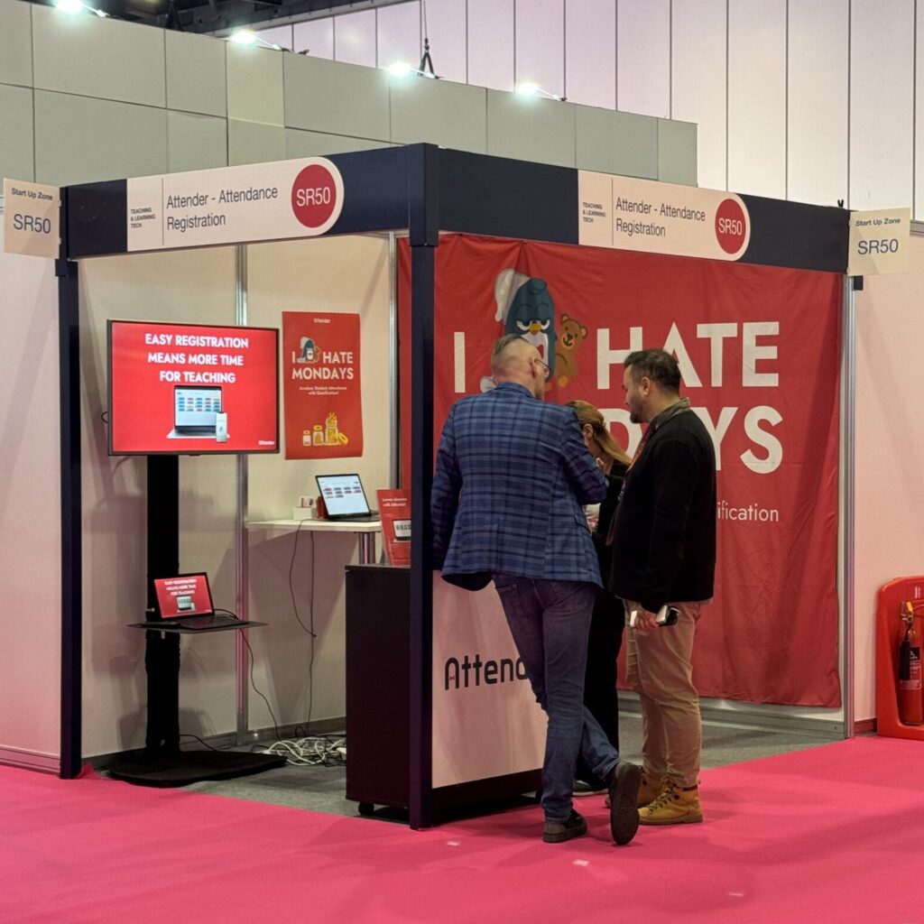 Two men at an exhibition stand talking to each other.