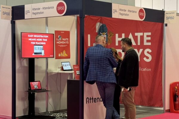 Two men at an exhibition stand talking to each other.